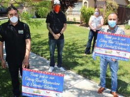 Group distributing signs thanking essential workers