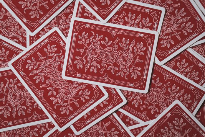 How comparison platforms highlight best payout casinos Scattered red playing cards.