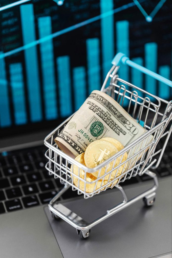 Crypto impacts Gilroy Image of cash and physical bitcoins in a tiny shopping cart